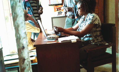 Customer seated beside a generator at a distribution company undertaking office in Lagos.