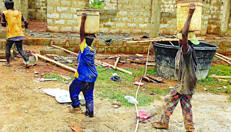 Some out-of-school boys working as labourers during school hours at a building site in the area
